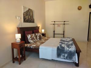 a bedroom with a bed and two lamps and a painting at Bustan Shells House in Muscat