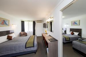 Llit o llits en una habitació de Burke & Wills Motor Inn