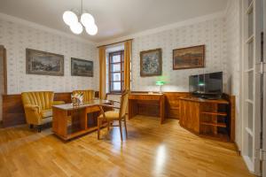 a living room with a television and a table and chairs at Penzion a restaurace U Míšků in Třeboň