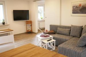 a living room with a couch and a table at Ferienhaus - Kann in Vollerwiek
