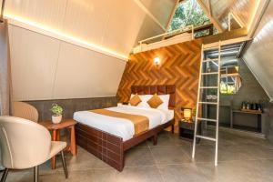 a bedroom with a bed and a ladder in a room at Alaya stays Inara Retreat 1-Cottage with a Mezzanine Loft, Shared Pool, and Garden in Bangalore