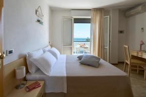 a bedroom with a bed with a view of the ocean at Hotel Dolores in Cesenatico