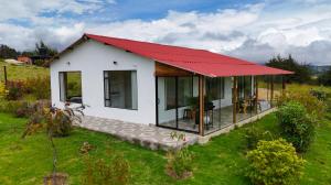 a small white house with a red roof at Finca Siberia, Sisga in Tilatá