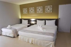 two beds in a hotel room with white towels on them at Pupha&Sila Home Resort in Betong +20 photos