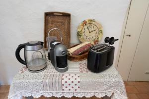 ein Tisch mit Kaffeemaschine, Mixer und Uhr in der Unterkunft Villa Morea-Relax in piscina in Putignano
