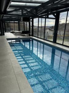 a swimming pool in a building with a view at Relax Walding in Jörgensbühl