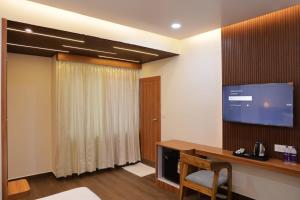 a room with a desk and a tv on the wall at Hotel Pritika Inn in Samastīpur +14 photos