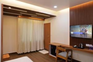 a room with a desk and a tv on the wall at Hotel Pritika Inn in Samastīpur