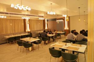 a dining room with people sitting at tables at Hotel Pritika Inn in Samastīpur