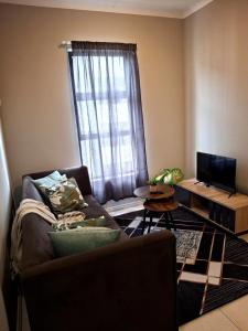 a living room with a couch and a window at Oak and Olive Retreat Midrand in Midrand