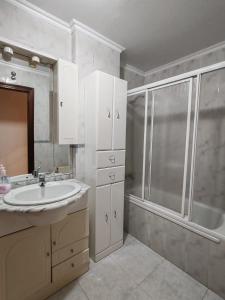 a bathroom with a sink and a shower at Apartamentos Quien Anda Ahí Ribadeo in Ribadeo +18 photos
