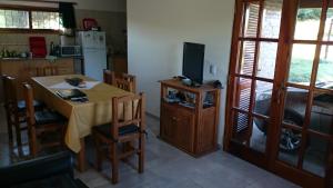 a kitchen with a table with a television and a kitchen with a tableablish at Cabañas De Cara al Sol in Villa Giardino