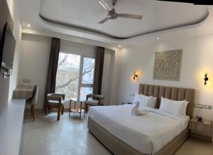 a bedroom with a bed and a desk and a window at Hotel Ivory Hills in Kotdwāra