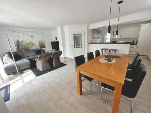 a living room with a dining table and a kitchen at Dorf 36 in Ording