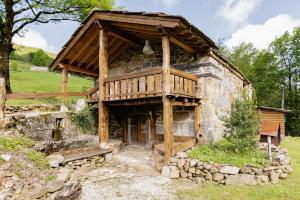 an old stone house with a wooden roof at Cabañas con Encanto in San Roque de Ríomiera