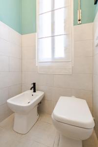 a white bathroom with a toilet and a sink at La casetta POP in Bordighera +28 photos