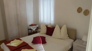 a bedroom with a white bed with red pillows at Apartments Lena in Podgora +68 photos