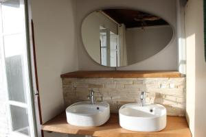 a bathroom with two sinks and a mirror at Oasis de Compostelle in Lauzerte