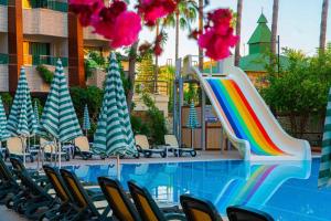 a pool with chairs and a slide at a resort at CLUB MONTE CARLO HoTEL in Alanya +20 photos