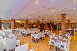 a dining room with white tables and chairs at CLUB MONTE CARLO HoTEL in Alanya