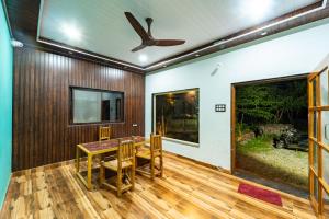 a dining room with a table and a ceiling fan at Dandeli River Valley Resort in Dandeli