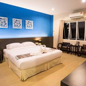 a bedroom with a large bed with a blue wall at Pupha&Sila Home Resort in Betong