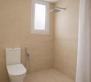 a bathroom with a toilet and a window at Navigo house Vrachati in Vrachati +15 photos