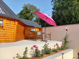 a patio with a table and a pink umbrella at Lodge Mon Petit Lapin in Montgon