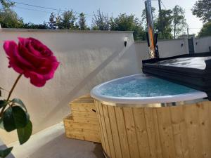 a hot tub with a pink rose and a flower at Lodge Mon Petit Lapin in Montgon