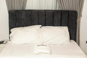 a bed with a black headboard and white pillows at Nestoria in Sagisa +1 photo