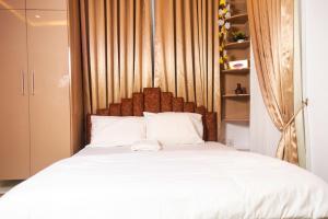 a bedroom with a white bed with a wooden headboard at Nestoria in Sagisa