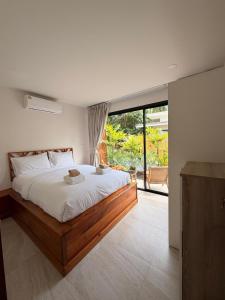a bedroom with a large bed and a large window at Srithanu Escape 1 in Srithanu