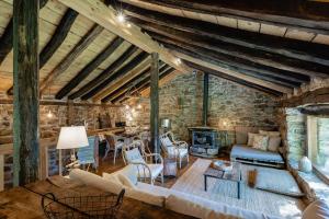a living room filled with furniture and a stone wall at Cabañas con Encanto in San Roque de Ríomiera