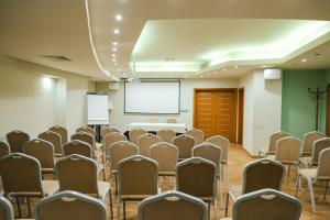 ein Konferenzraum mit Stühlen und einer weißen Leinwand in der Unterkunft Triada Hotel in Sofia