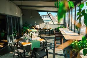 ein Restaurant mit Tischen, Stühlen und Fenstern in der Unterkunft Triada Hotel in Sofia