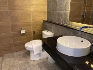 a bathroom with a white toilet and a sink at Pupha&Sila Home Resort in Betong