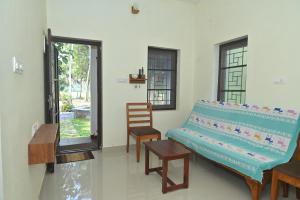 a living room with a bench and a chair at Nisarga Greens in Chittūr