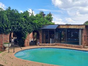 a swimming pool in front of a house with a building at Carey 43 in Bothaville