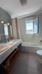 a bathroom with two sinks and a tub and a toilet at Casa Rural Nacimiento del Hueznar - Tomillo 17 in San Nicolás del Puerto +67 photos