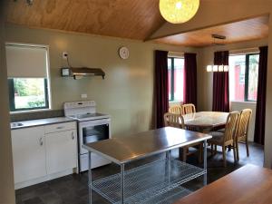 una cucina e una sala da pranzo con tavolo e sedie di Cedar Chalets a Methven