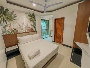 a bedroom with a bed in a room with a mural at The Town - By Namal in El Nido