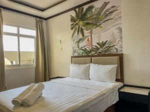 a bedroom with a bed with two towels on it at The Town - By Namal in El Nido