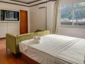 a bedroom with a bed and a chair and a window at The Town - By Namal in El Nido +18 photos