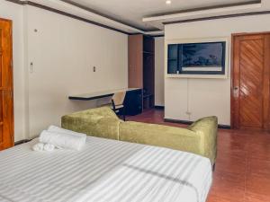 a bedroom with a bed and a couch and a tv at The Town - By Namal in El Nido