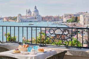 un tavolo con del cibo su un balcone con vista sull'acqua di Locanda Vivaldi a Venezia Altre 30 foto