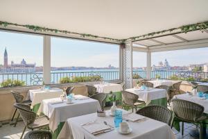 un ristorante con tavoli e sedie con vista sull'acqua di Locanda Vivaldi a Venezia