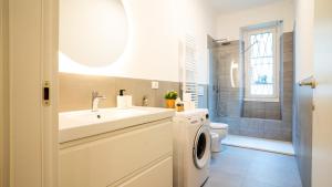 a bathroom with a sink and a washing machine at Ramazzini District – Elegant Flat x8 in Milan