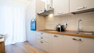 a kitchen with white cabinets and a sink at Ramazzini District – Elegant Flat x8 in Milan +26 photos