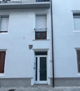 a white building with a door and a balcony at Casa Isabella in Nuoro