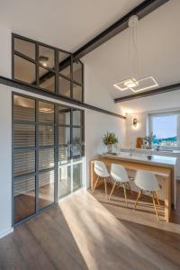 a kitchen with a large wooden table and white chairs at Casa Emily in Portovenere